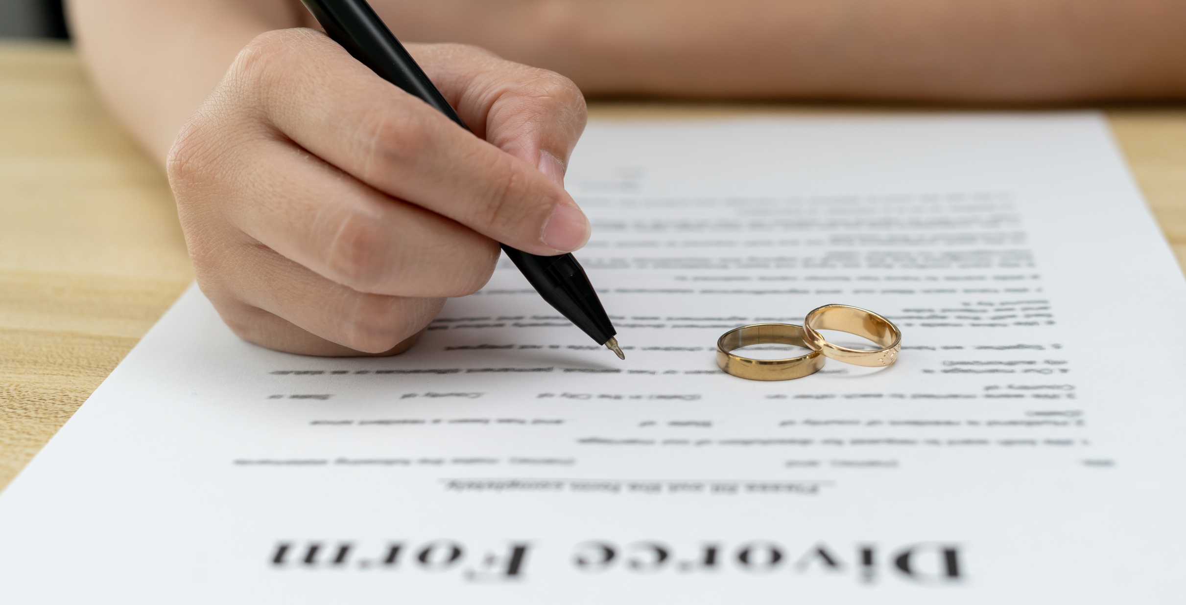 Divorce. Woman remove married ring and sign Divorce form.