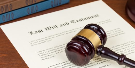 Last will and testament with wooden judge gavel; document is mock-up not real
